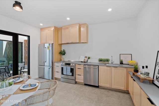 kitchen featuring appliances with stainless steel finishes, recessed lighting, a sink, and light brown cabinetry