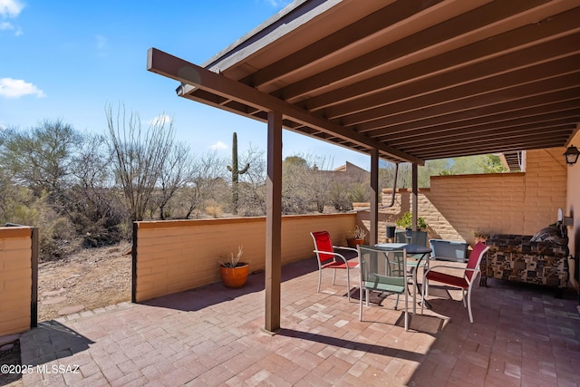 view of patio featuring outdoor dining area and fence