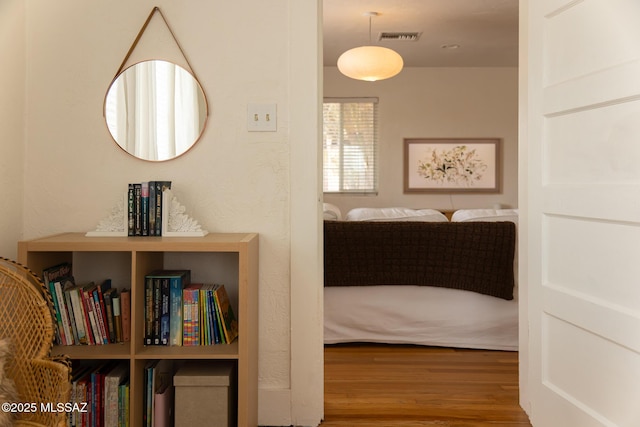hallway with visible vents and wood finished floors