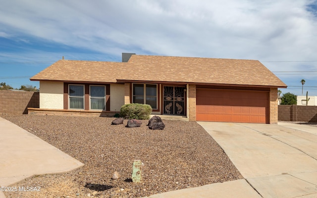 ranch-style home with a garage, fence, driveway, roof with shingles, and stucco siding