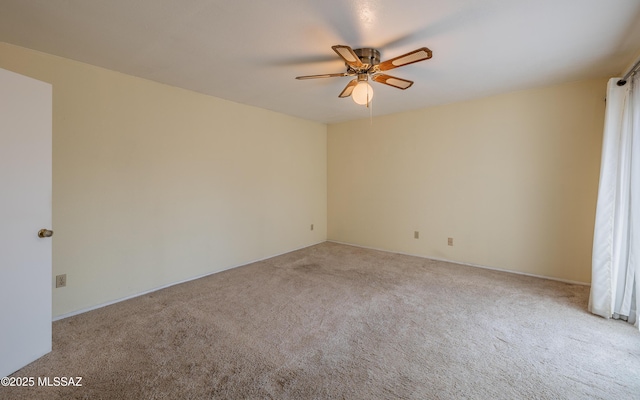 spare room featuring a ceiling fan and carpet