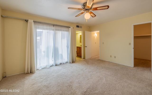 unfurnished bedroom featuring ensuite bath, ceiling fan, visible vents, and carpet flooring