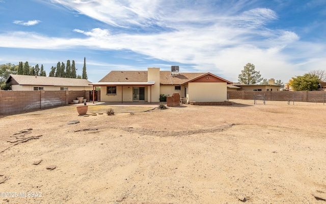rear view of property featuring a fenced backyard and a patio