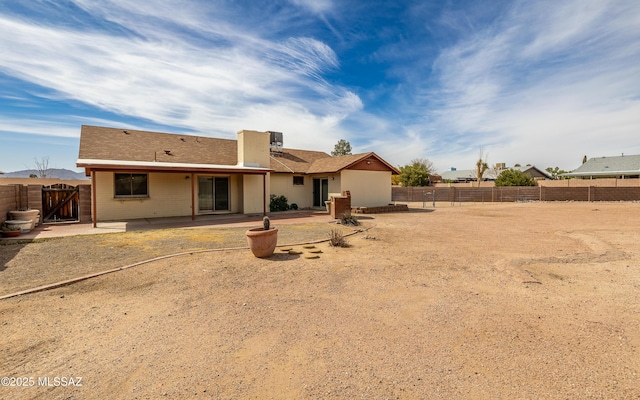 rear view of property with a patio, a fenced backyard, and a gate