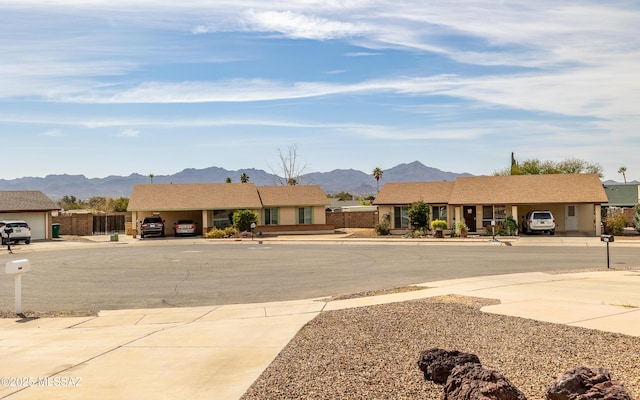 view of road with driveway, sidewalks, and a mountain view