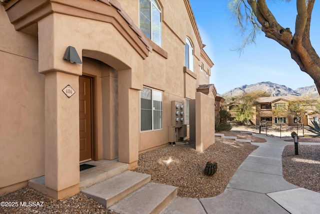 doorway to property with a mountain view and stucco siding