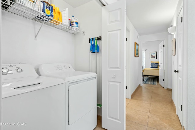 laundry room with light tile patterned floors, laundry area, and washing machine and dryer