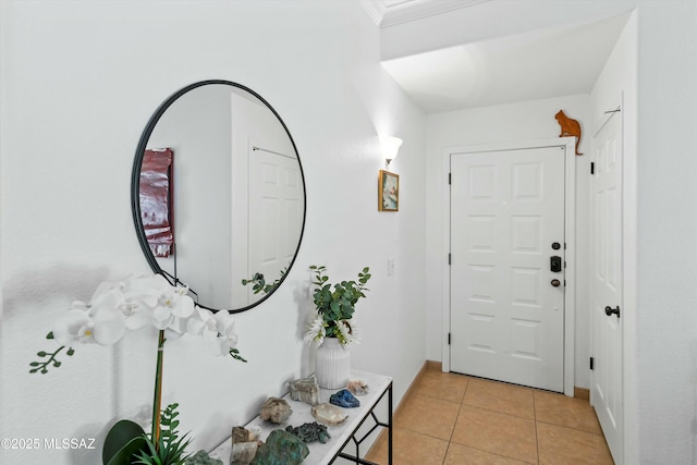 foyer entrance featuring light tile patterned floors, baseboards, and ornamental molding