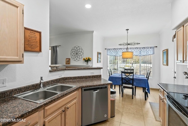 kitchen with light tile patterned floors, dark countertops, appliances with stainless steel finishes, decorative light fixtures, and a sink