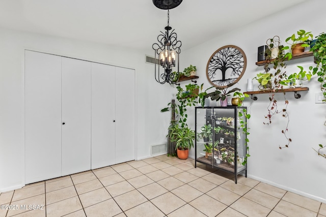 interior space with an inviting chandelier, baseboards, light tile patterned floors, and visible vents