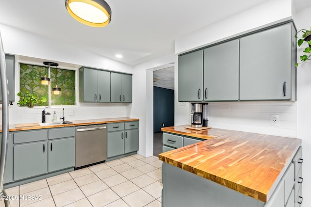 kitchen with gray cabinetry, stainless steel dishwasher, wooden counters, backsplash, and light tile patterned flooring