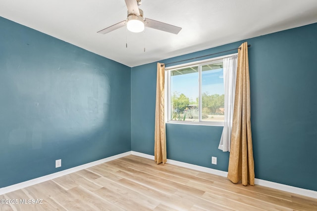 unfurnished room with a ceiling fan, baseboards, and wood finished floors