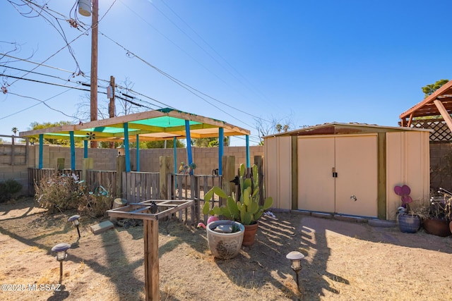 view of yard featuring a fenced backyard, a storage unit, and an outdoor structure