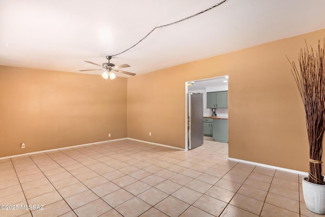 unfurnished room featuring ceiling fan, baseboards, and light tile patterned floors