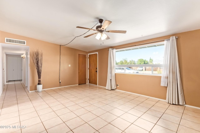 unfurnished room with light tile patterned floors, ceiling fan, visible vents, and baseboards