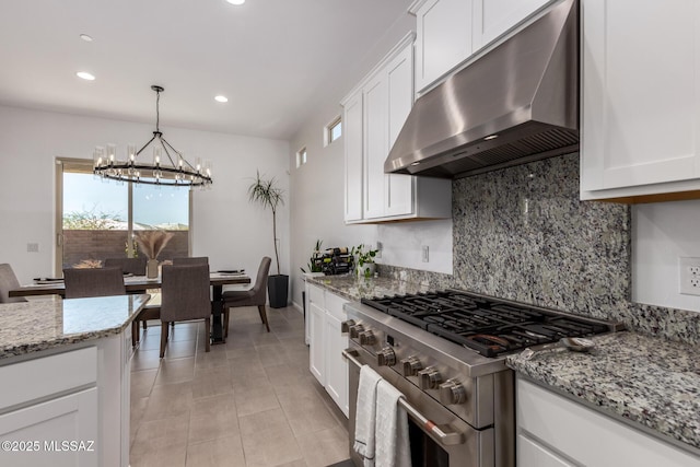 kitchen with stainless steel stove, backsplash, white cabinets, a chandelier, and extractor fan