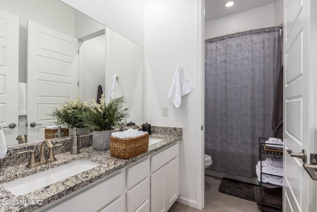 bathroom with double vanity, toilet, a shower with curtain, tile patterned floors, and a sink