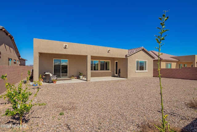 back of property featuring a fenced backyard, a patio, and stucco siding