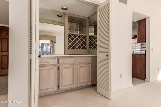 wine room with light carpet, visible vents, and a dry bar