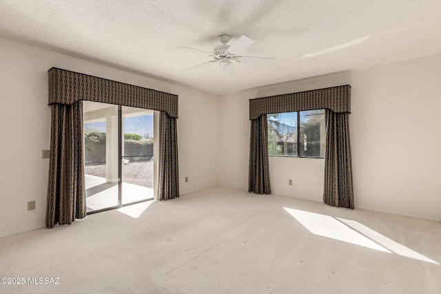 unfurnished room featuring carpet, ceiling fan, and a textured ceiling