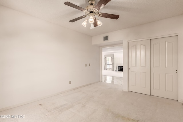 unfurnished bedroom featuring baseboards, visible vents, a ceiling fan, carpet floors, and a closet