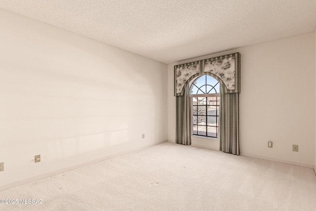 unfurnished room featuring carpet flooring, a textured ceiling, and baseboards