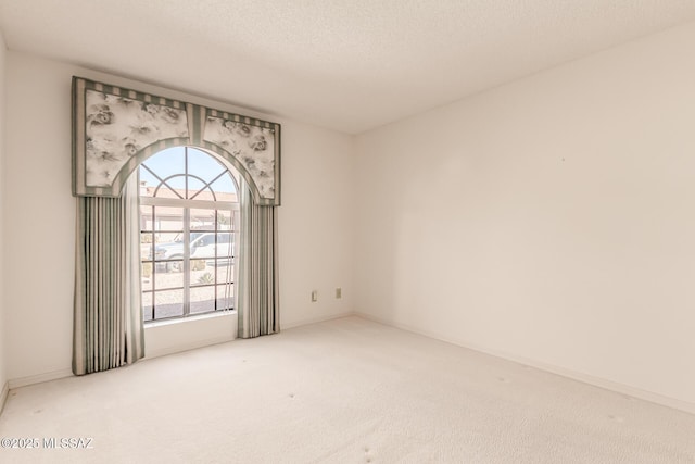 carpeted spare room featuring a textured ceiling