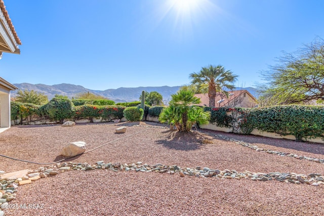 view of yard featuring fence and a mountain view