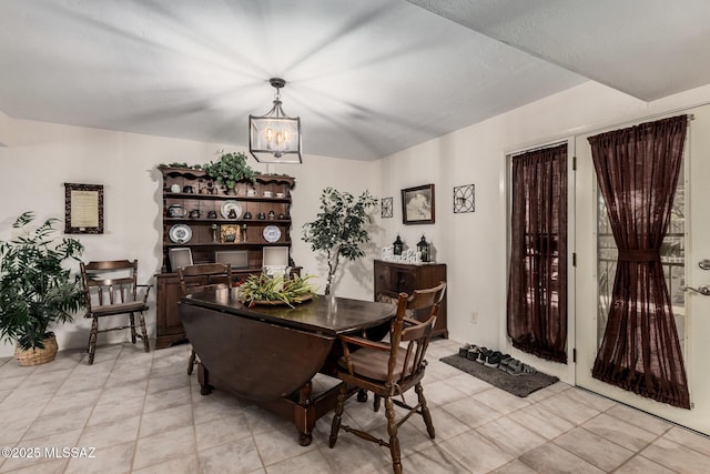 dining area featuring light tile patterned floors and an inviting chandelier