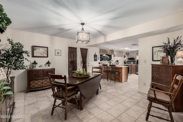 dining space featuring light tile patterned floors, baseboards, and a notable chandelier