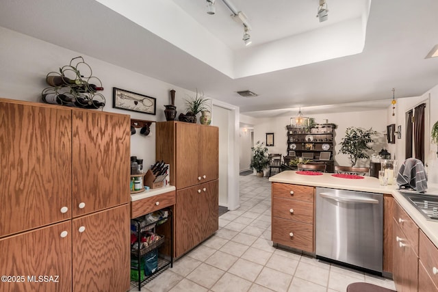 kitchen featuring light countertops, stainless steel dishwasher, visible vents, and brown cabinets