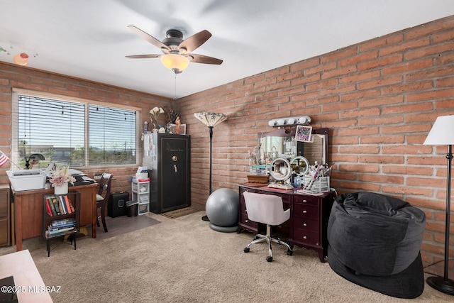 home office with brick wall, a ceiling fan, and light colored carpet