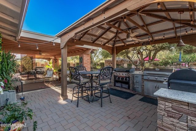 view of patio featuring a ceiling fan, area for grilling, grilling area, and a gazebo