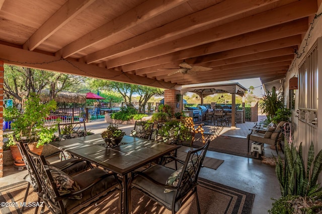 view of patio featuring outdoor dining area, ceiling fan, and fence