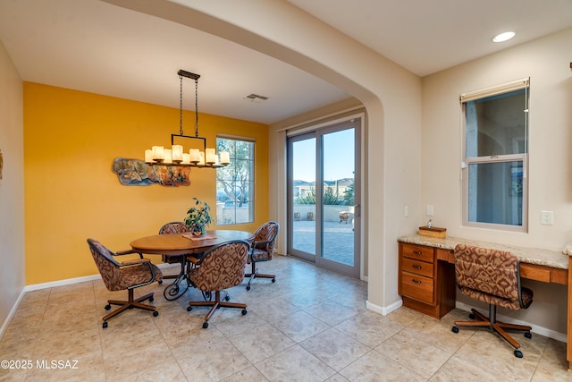 dining room with visible vents, baseboards, arched walkways, and a chandelier