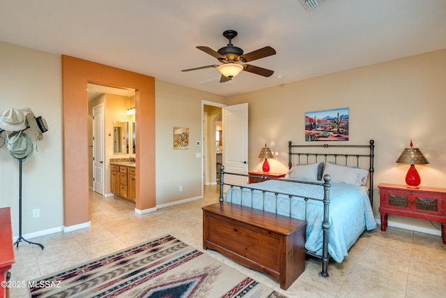 bedroom with a ceiling fan, light tile patterned flooring, connected bathroom, and baseboards