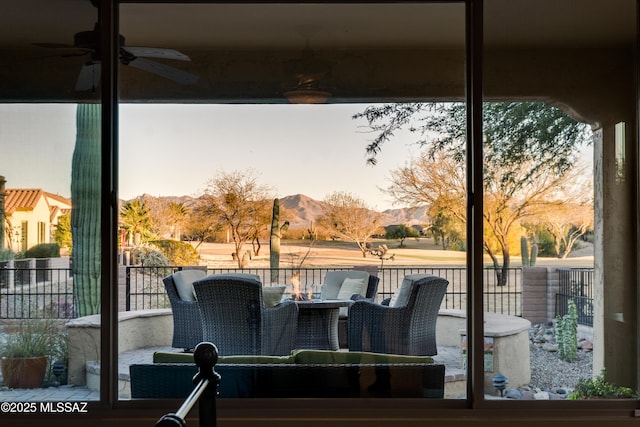 deck with ceiling fan, fence, and a mountain view