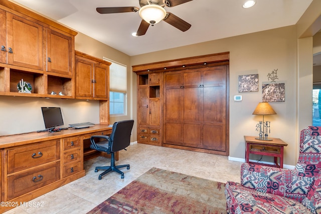 office with ceiling fan, light tile patterned floors, built in desk, and baseboards