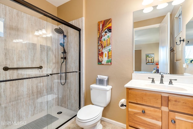 full bath featuring toilet, a stall shower, vanity, baseboards, and tile patterned floors