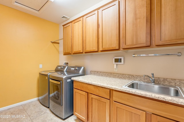 laundry area featuring washing machine and clothes dryer, light tile patterned floors, cabinet space, visible vents, and a sink