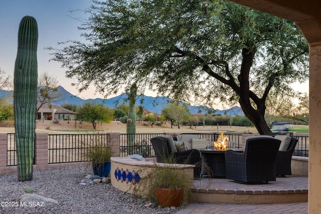 view of patio featuring fence, a fire pit, and a mountain view