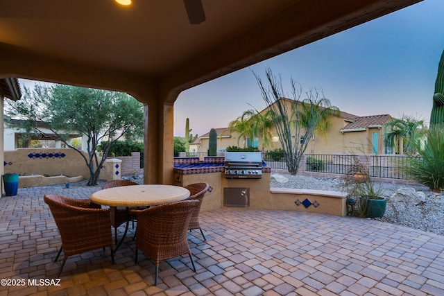 view of patio with exterior kitchen, outdoor dining area, area for grilling, and fence