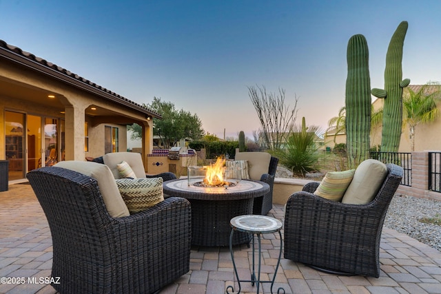 patio terrace at dusk featuring an outdoor fire pit