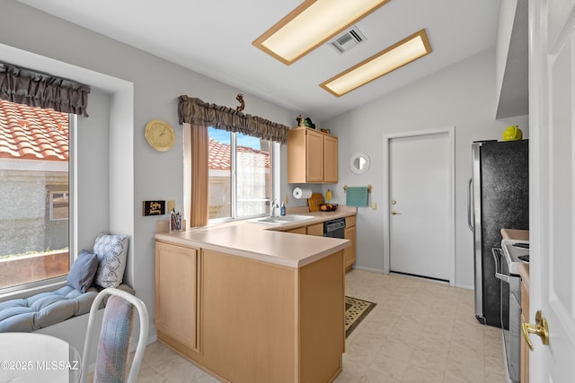 kitchen with lofted ceiling, light countertops, light brown cabinets, a sink, and a peninsula