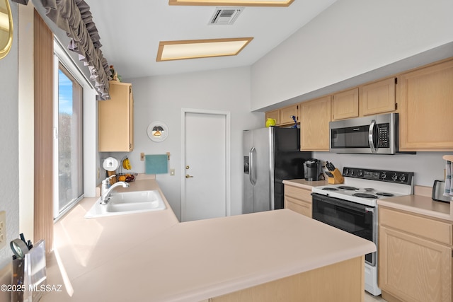 kitchen featuring visible vents, stainless steel appliances, light countertops, light brown cabinets, and a sink