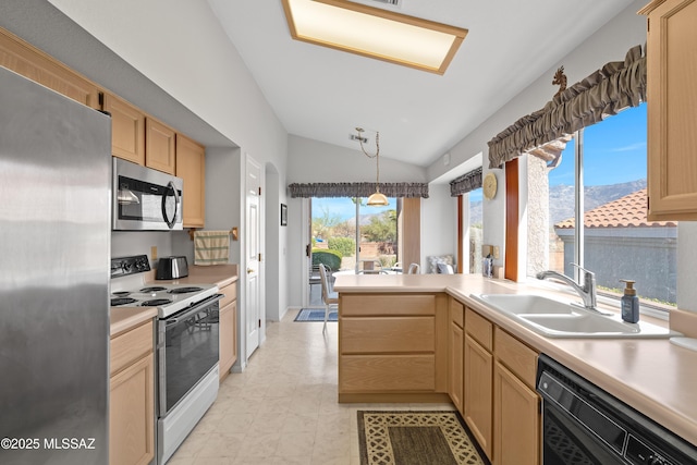 kitchen with appliances with stainless steel finishes, light countertops, a sink, and light brown cabinetry