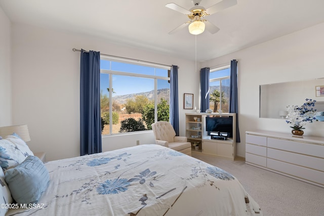 bedroom with multiple windows, a ceiling fan, and light colored carpet