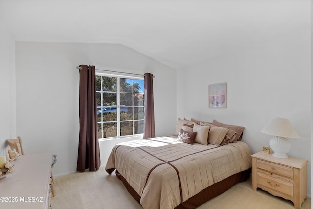 bedroom with lofted ceiling and light colored carpet