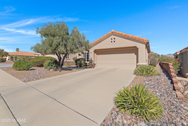 view of front of house featuring a garage, concrete driveway, a tiled roof, and stucco siding