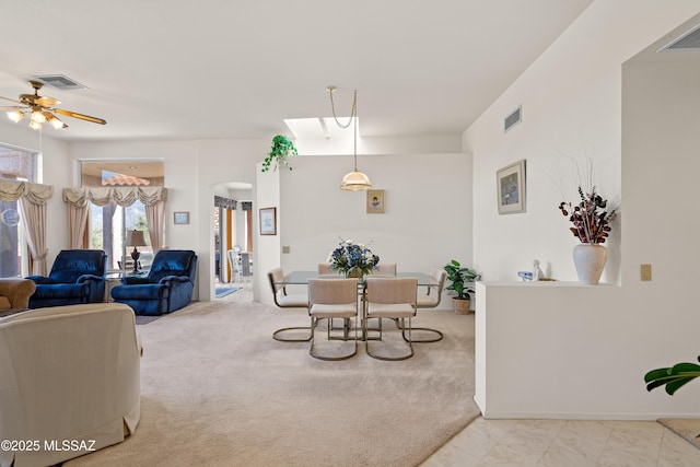 dining area with visible vents, ceiling fan, and light carpet